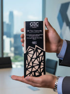 Person holding a GEC award with a cityscape in the background