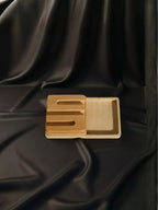 Wooden tray with a lid on a black fabric background