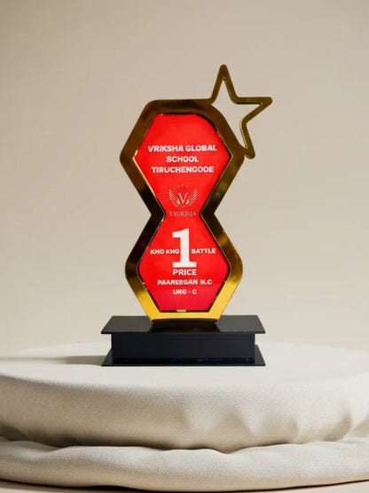 Decorative trophy with red and gold design on a white surface