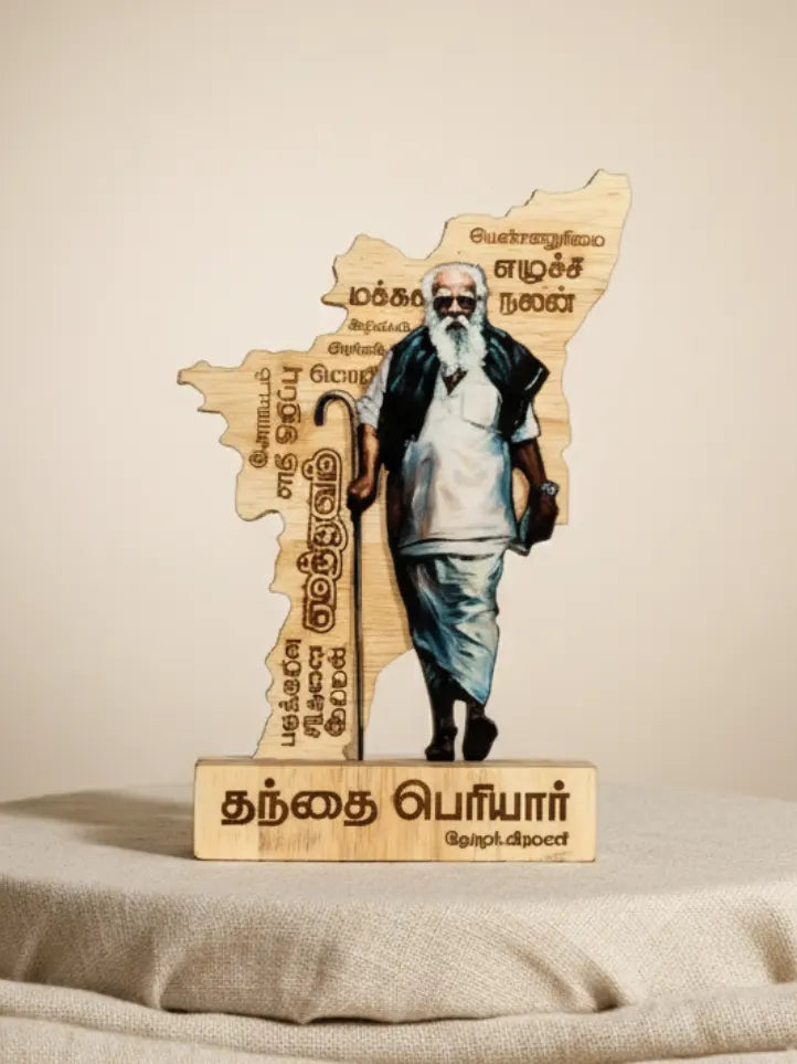 Wooden sculpture of a man with a walking stick on a map of Tamil Nadu, featuring text.