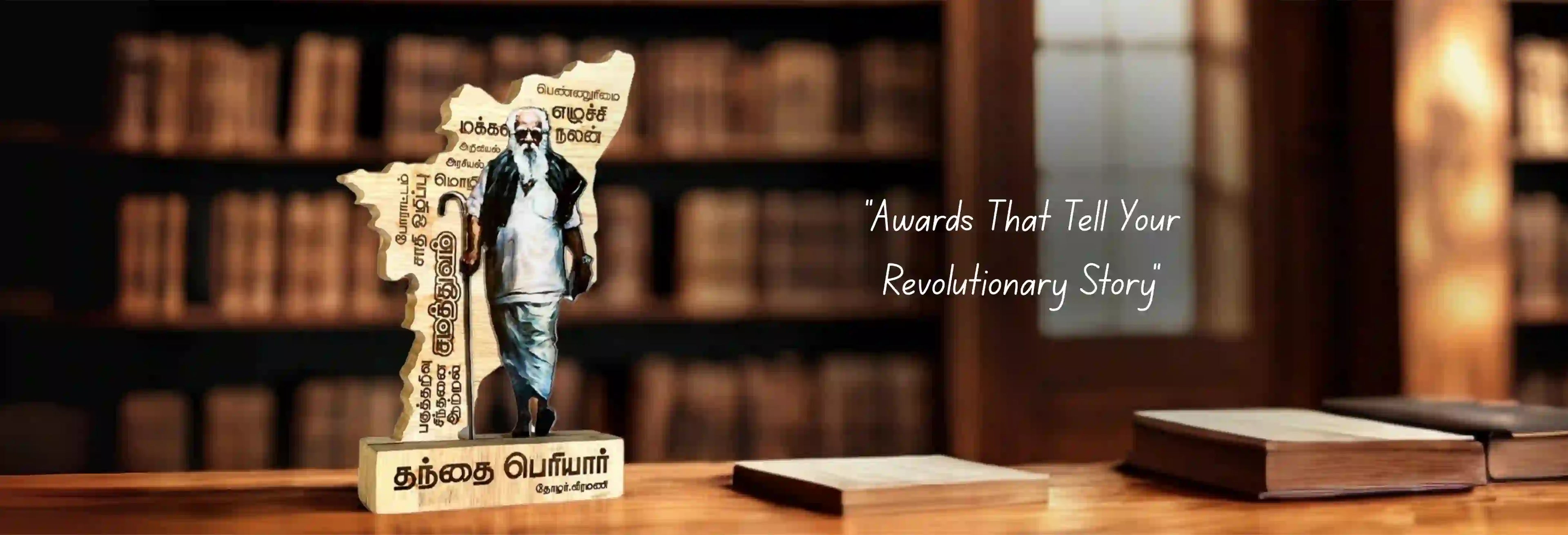 Statue on a wooden base with text 'Awards That Tell Your Revolutionary Story' against a blurred bookshelf background.