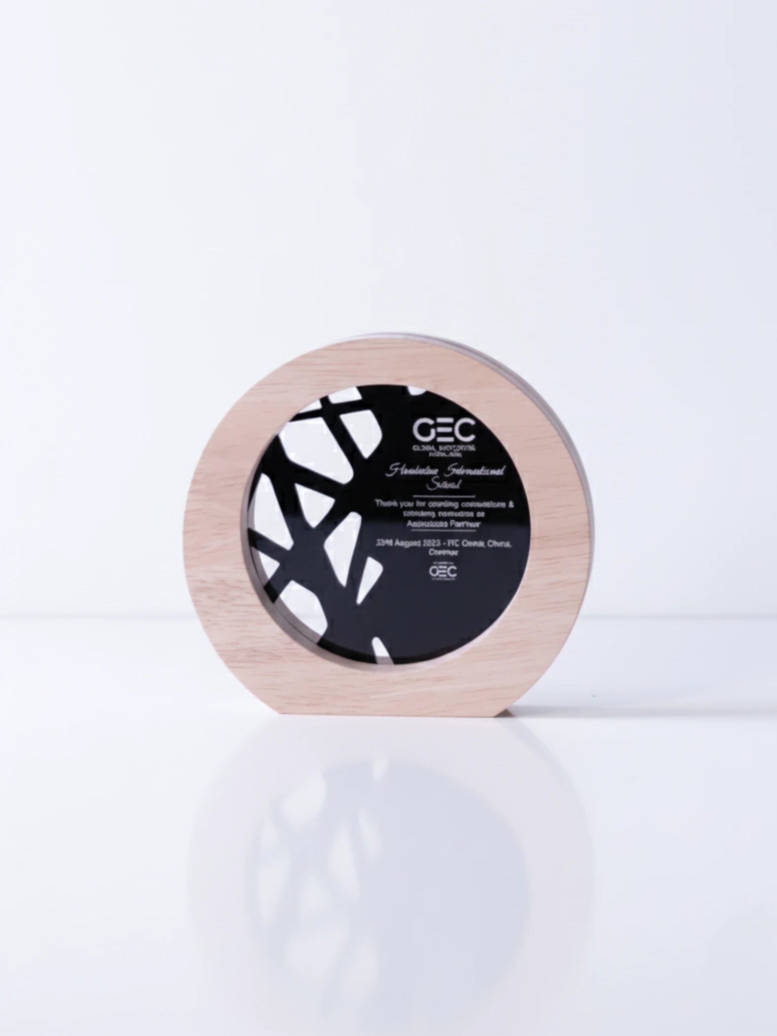 Round wooden product with black center and 'GEC' branding on a white background