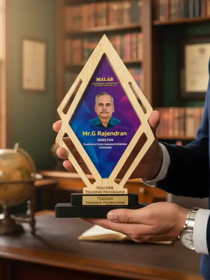 Person holding a diamond-shaped award with a portrait and text in an office setting.