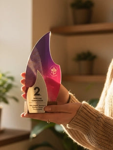 Person holding a decorative award with a blurred indoor background