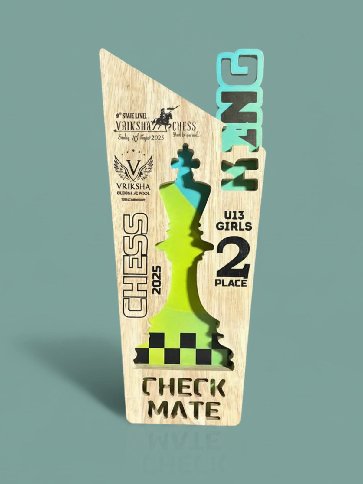 Wooden chess-themed trophy with green and blue design on a light gray background
