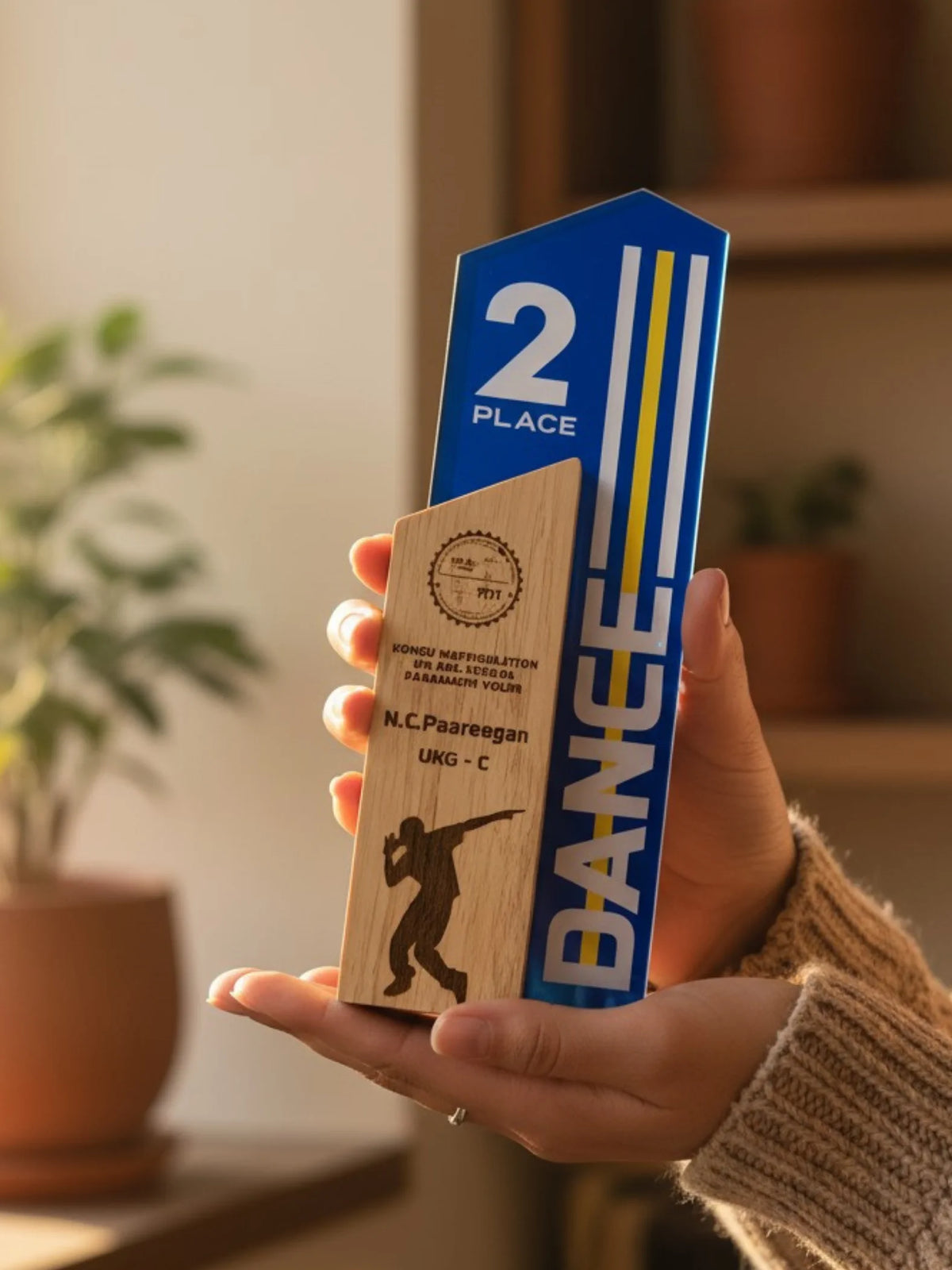 Hand holding a wooden and blue award with 'Bangee' branding and '2nd Place' text.