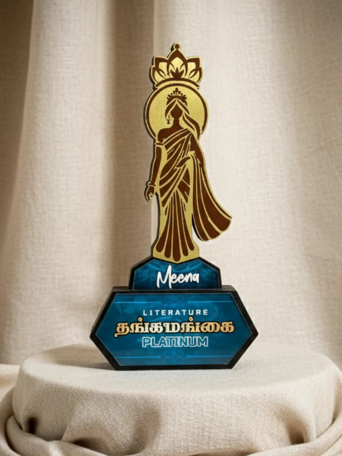 Decorative award with a figure and 'Meena' branding on a beige background
