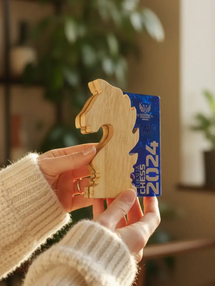 Hand holding a wooden chess piece with a 2024 card in front of a blurred indoor background