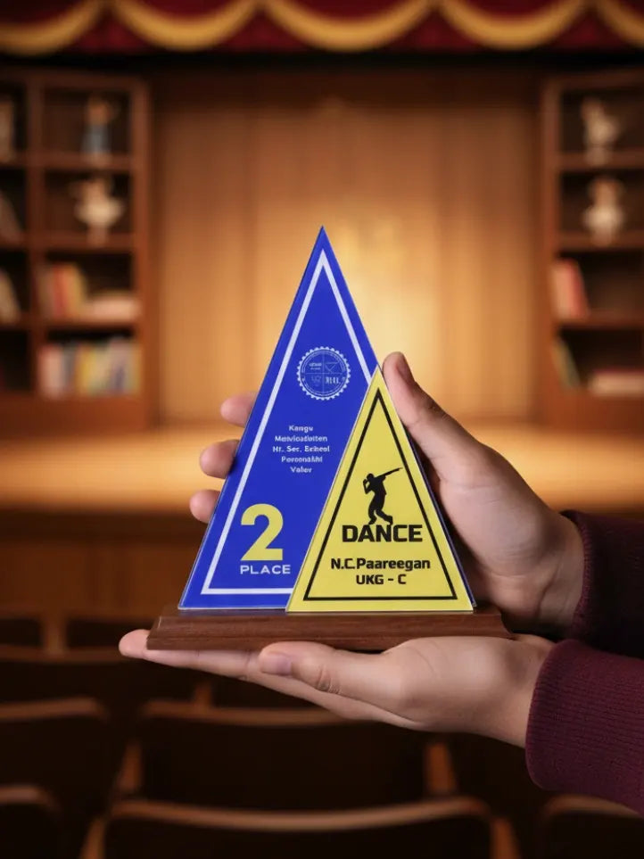 Triangular award with blue and yellow design held in front of a theater setting