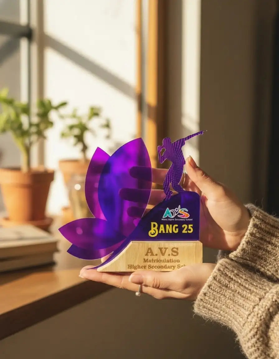 Person holding a purple and gold award with 'A.V.S' branding in a bright room.