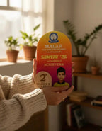 Person holding a colorful award plaque with a child's photo and text in a home setting.