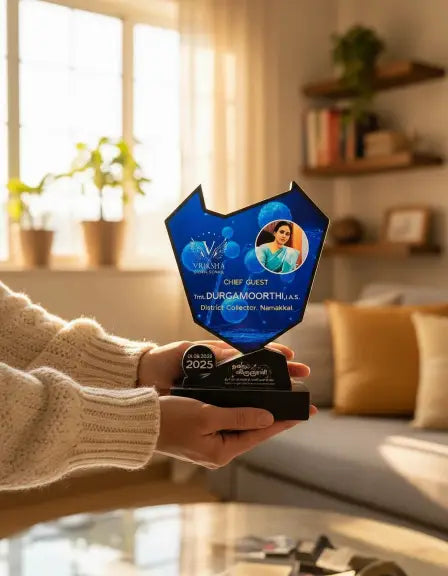 Person holding an award in a cozy living room with plants and books in the background