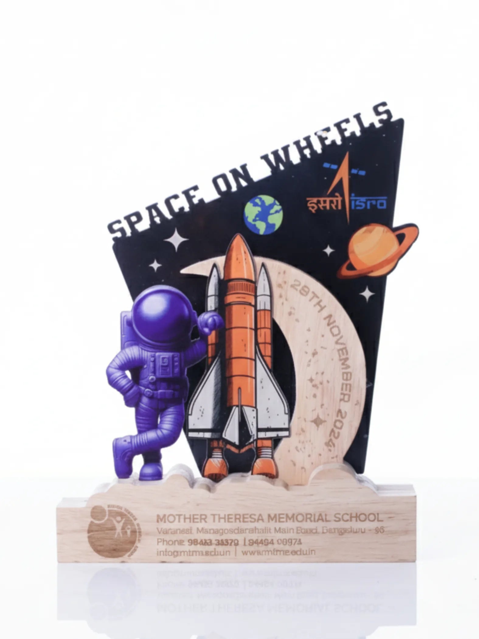 Space-themed figurine with an astronaut and rocket on a wooden base, against a white background.
