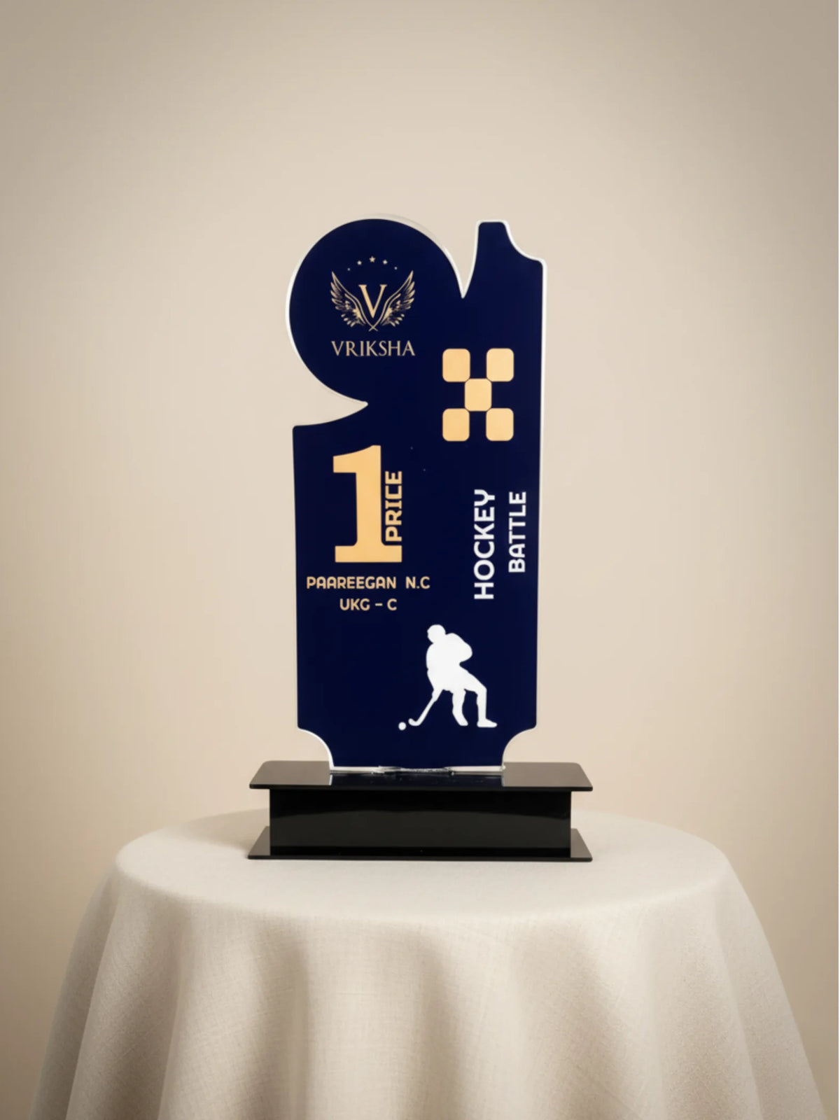 Navy blue trophy with gold accents on a beige background