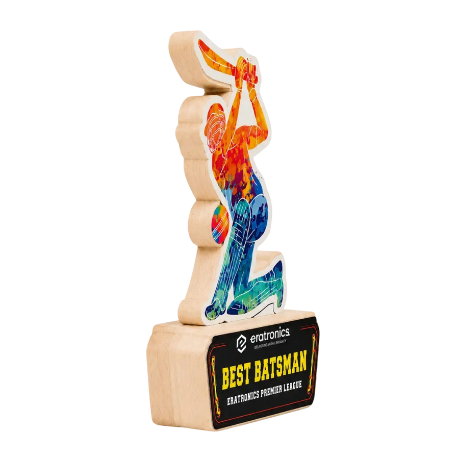 A wooden award trophy featuring a stylized figure of a cricket player in a colorful tie-dye