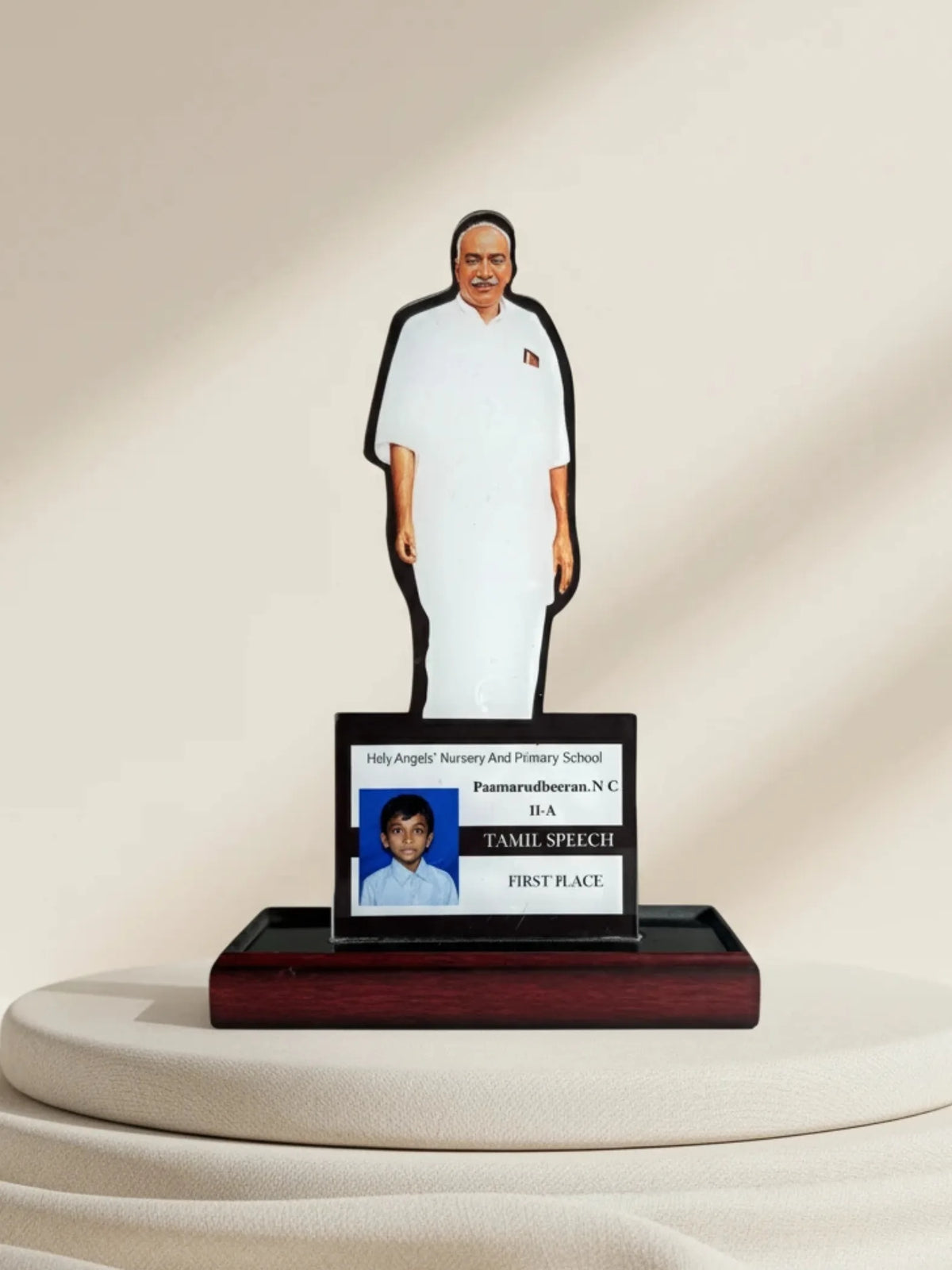 Cutout of a person with a nameplate on a pedestal against a beige background