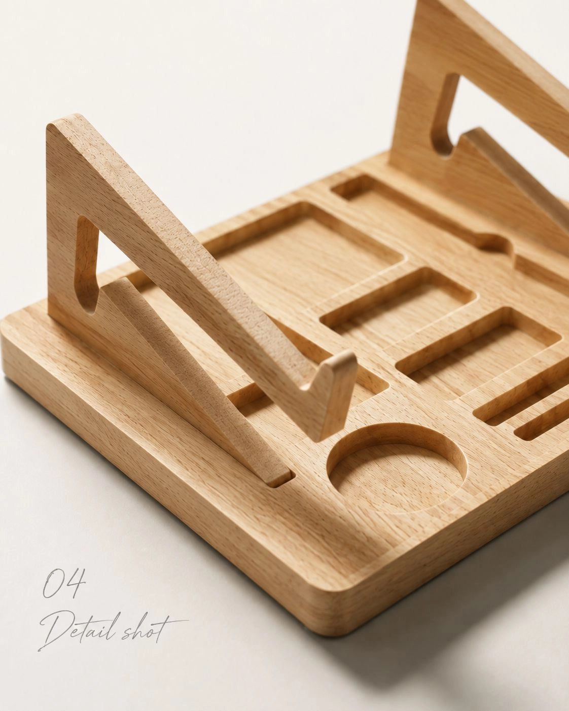 Close-up detail shot of a light natural wood organizer tray with geometric cutouts and triangular stand supports, photographed on a clean off-white background.