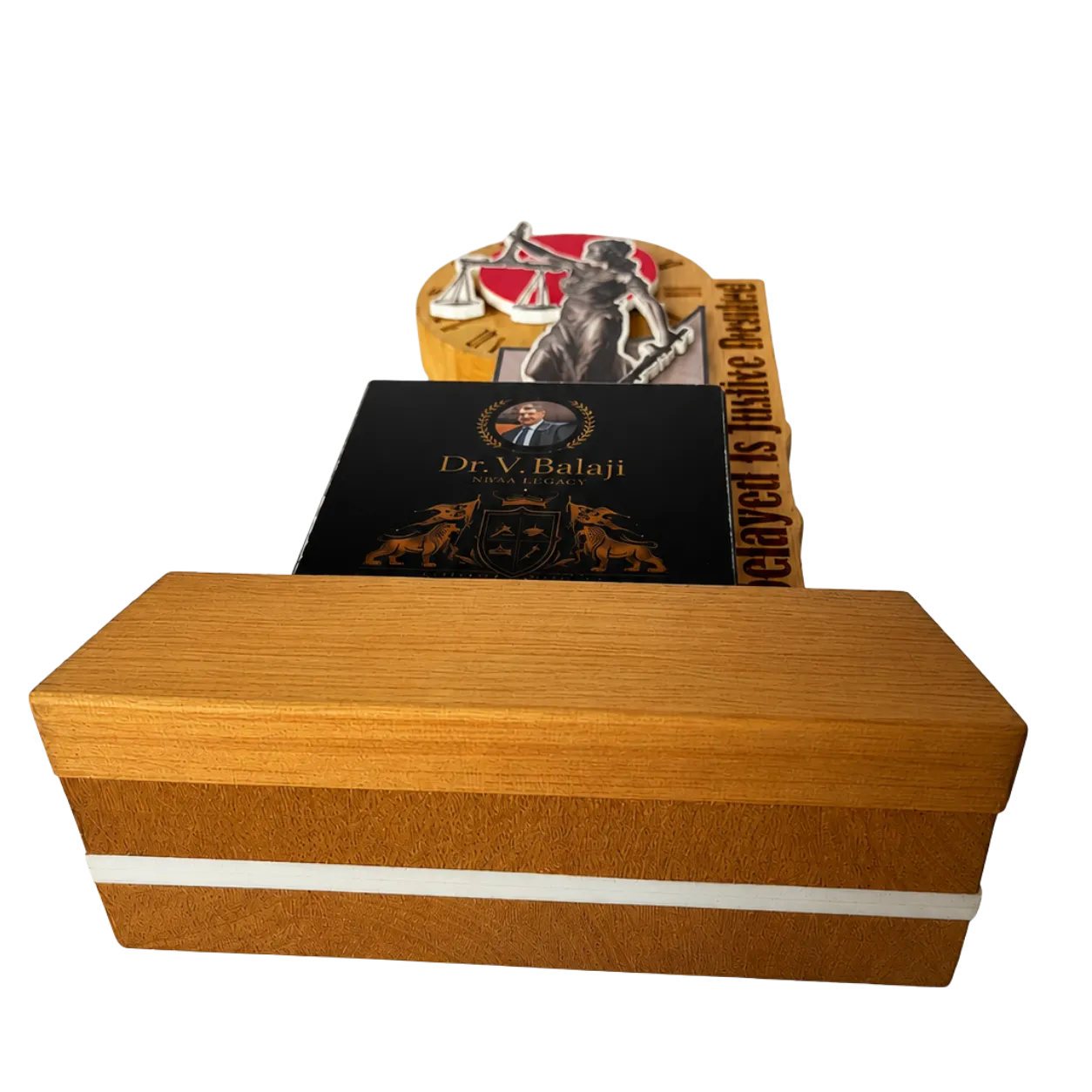 Wooden box with a black book and a small figurine on top against a white background