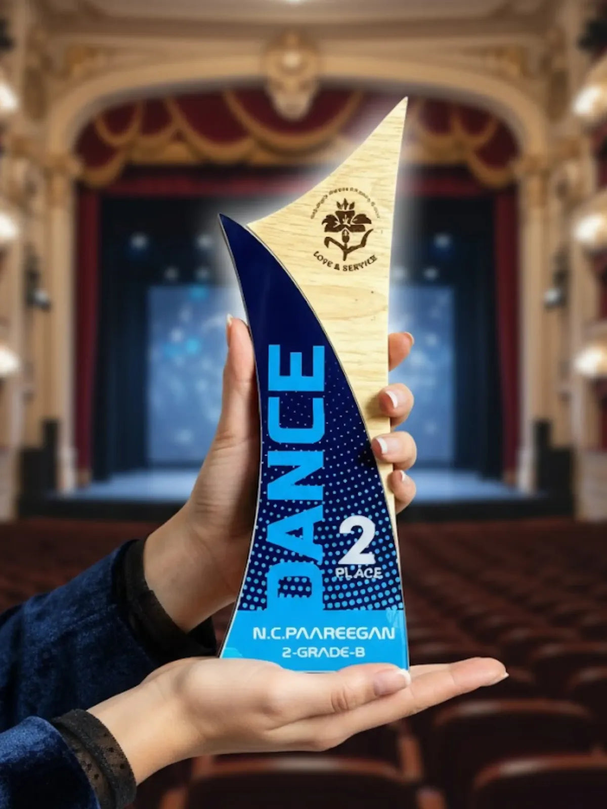 Person holding a blue and gold award in an auditorium