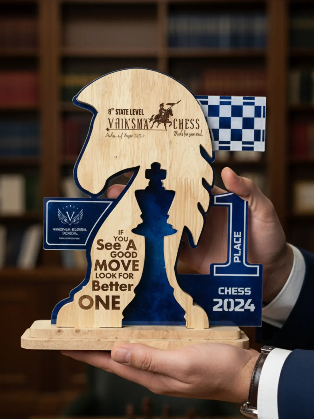 Wooden chess-themed trophy with blue and brown design, held by a person in a formal setting.