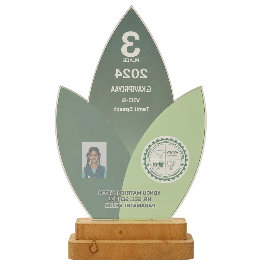 Decorative award with green leaf design, wooden base, and photo of a person.