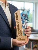 Person holding a wooden award with 'Vriksha Global School' branding